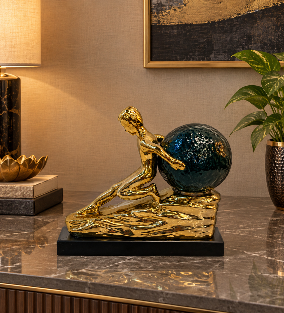 Gold Male Figure Pushing Teal Globe Sculpture on Black Base